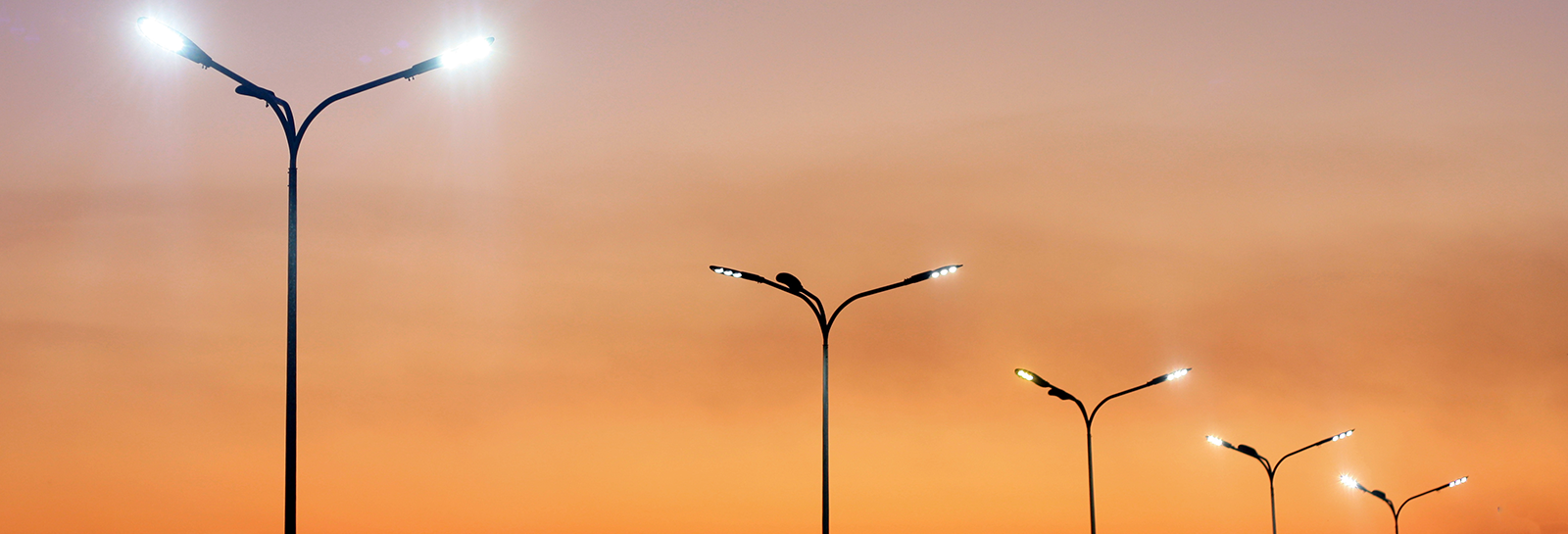 Row of street lights against night sky banner image